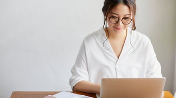 Woman in white shirt typing on laptop | Wavelength medical recruitment