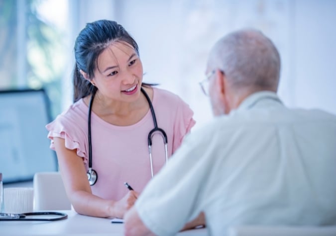 female GP with male patient in clinic consultation