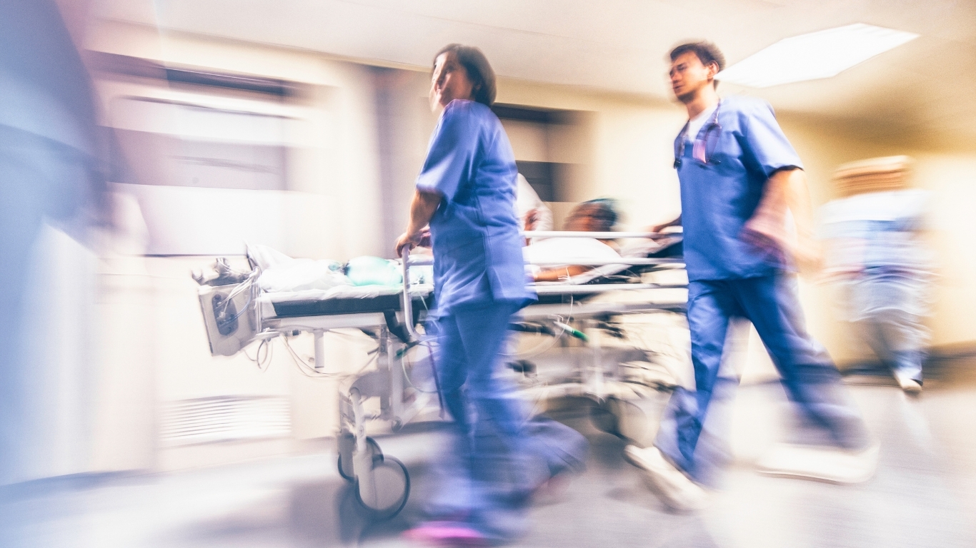 emergency doctors with patient in hospital bed